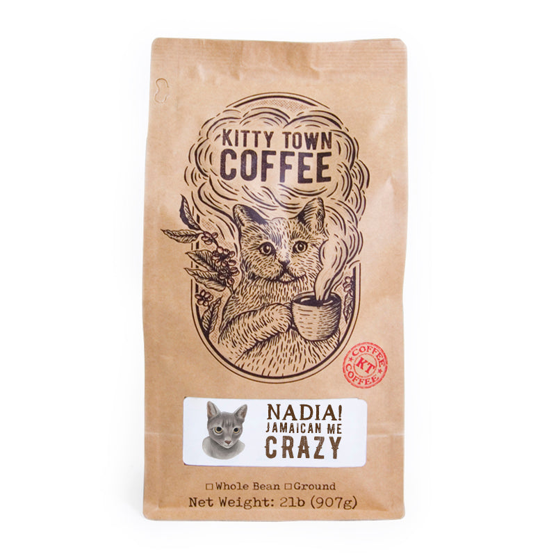 A bag of Nadia! Jamaican Me Crazy! coffee blend featuring hazelnut and caramel flavors, with a playful design representing the Kitty Town family.